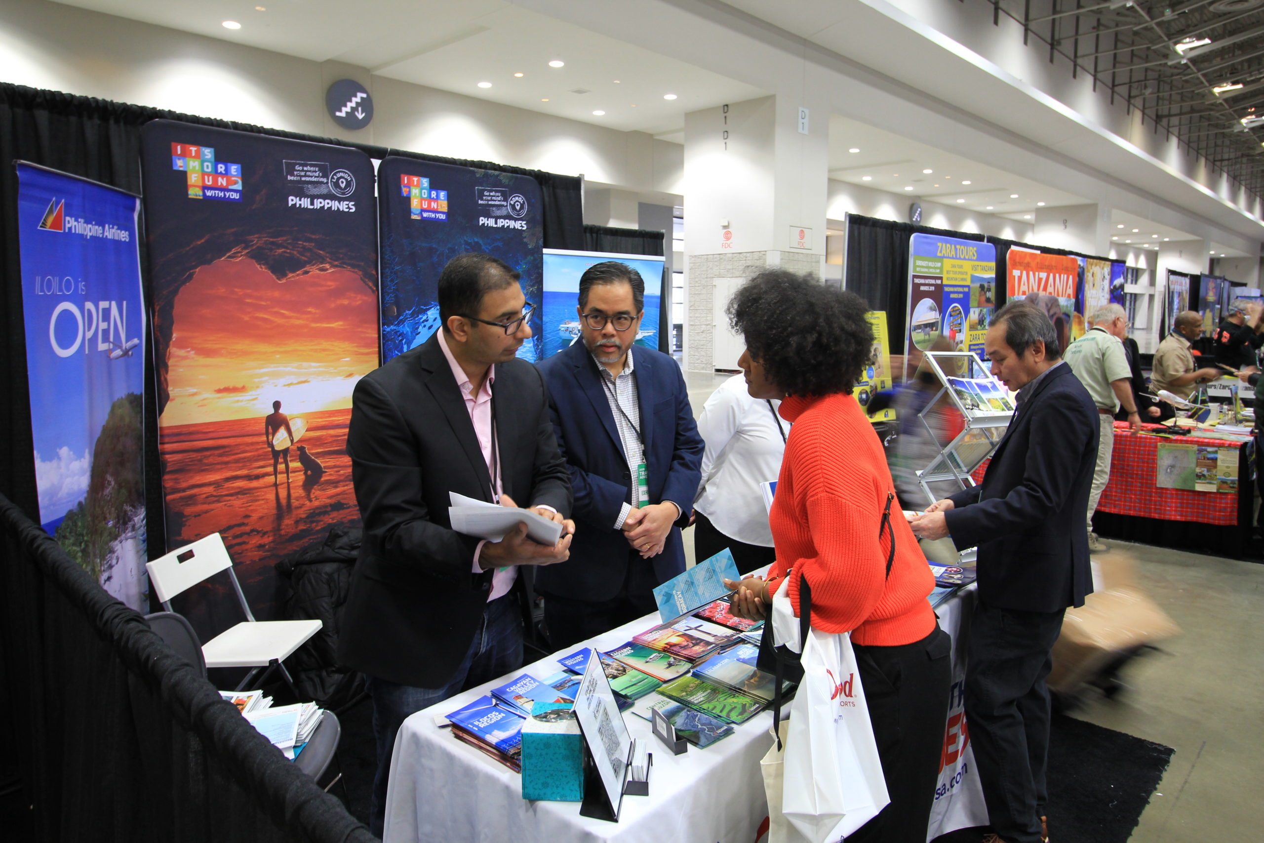PAL Executive Syed Shahid (left) and Charge d’Affaires,  a.i. Jaime Ramon Ascalon, Jr. (right) engage a participant at the Philippines' Booth at the Washington DC travel and adventure Expo