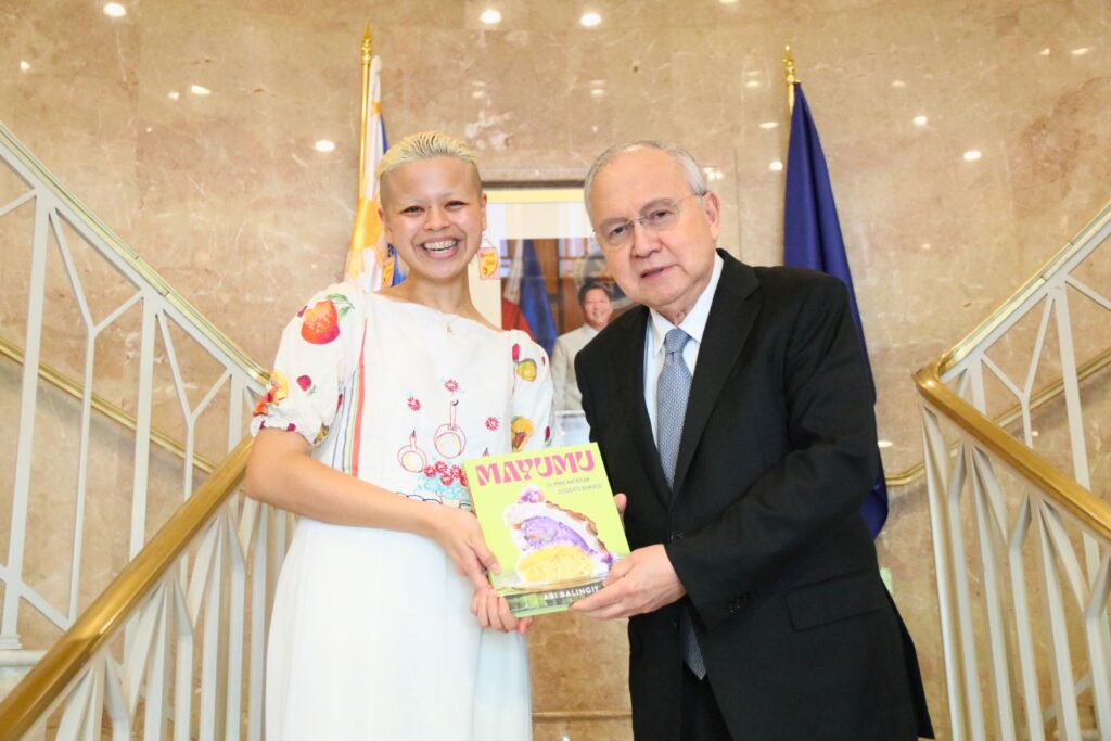 Ambassador Jose Manuel G. Romualdez (right) receives a copy of “Mayumu: Filipino American Desserts Remixed” from the author, Ms. Abi Balingit.