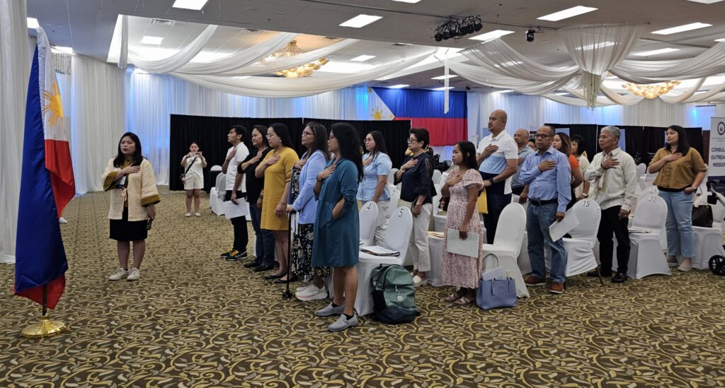 Consul Barbie Rosales (leftmost) leads the singing of the Philippine National Anthem after administering the oath of allegiance to dual citizens.