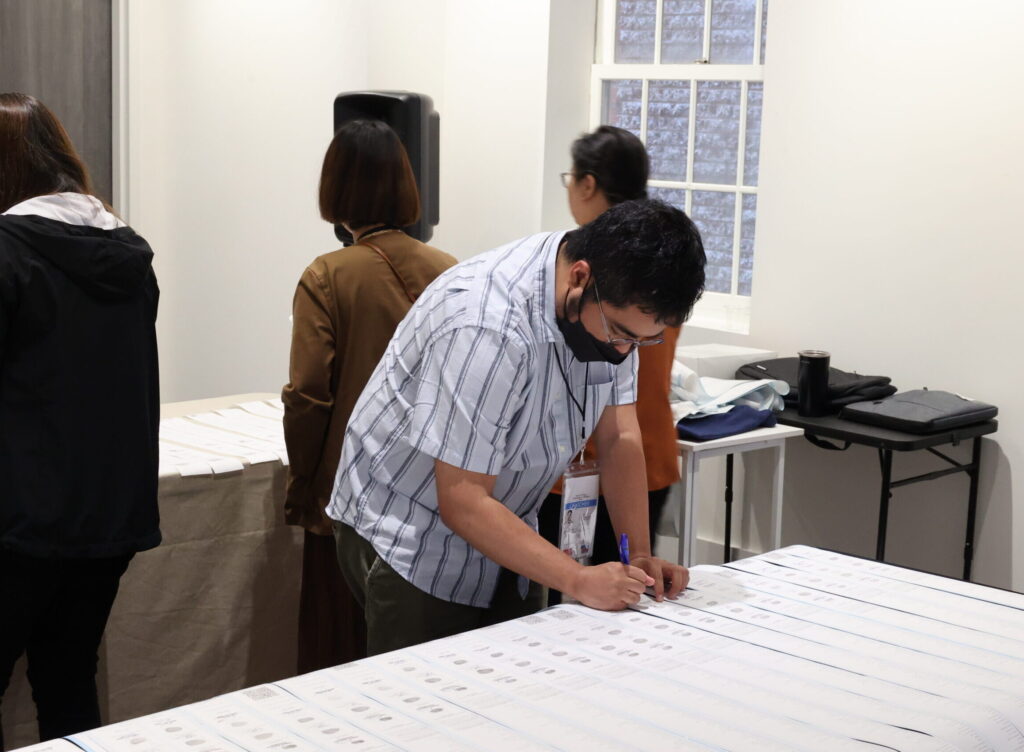 Mr. Jhonry Dela Cruz, watcher from Bayan Muna partylist, inspects and signs the election results. Watchers and accredited election observers participated in the Embassy’s conduct of the 2025 National Elections.
