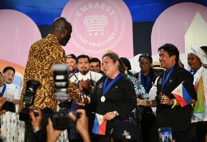 Chefs Paolo Peñalosa and Maria Carmel Tabligan proudly receive the People’s Choice Award from former ECC winner Chef Francis Otoo at the 2025 Embassy Chef Challenge, highlighting the distinctive tastes and culinary heritage of Filipino cuisine. (Photo credit: EventsDC)