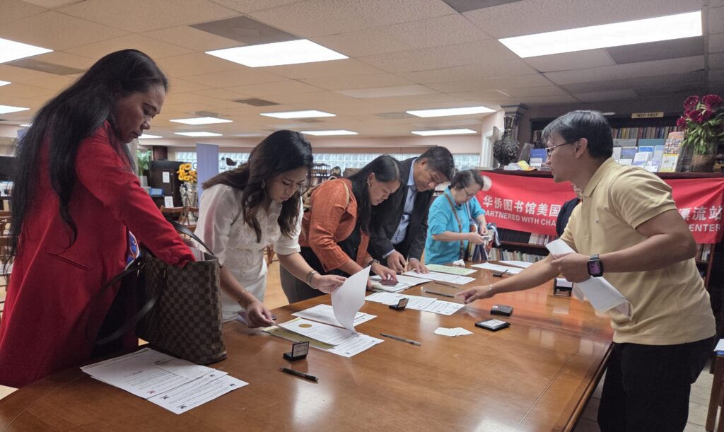 Clients check their identification certificates prior to taking their oath of allegiance at the Embassy’s consular mission in Charlotte, North Carolina, on 07 September 2025.