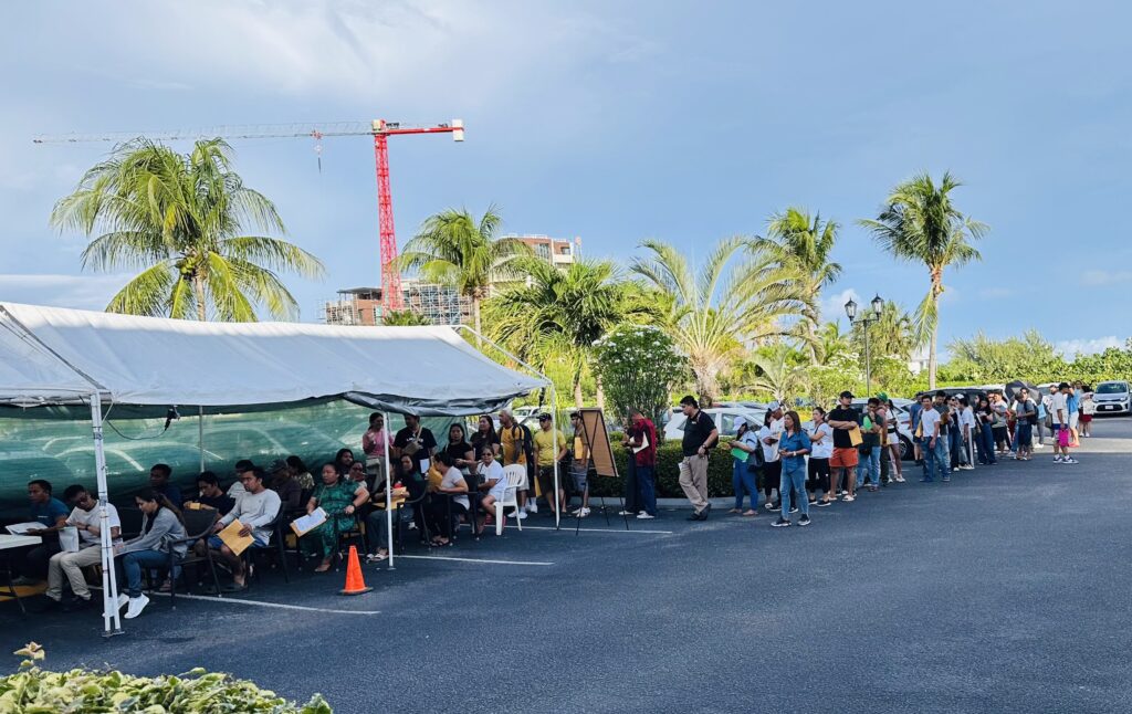 OFWs in Cayman Islands queue for MWO and OWWA services.