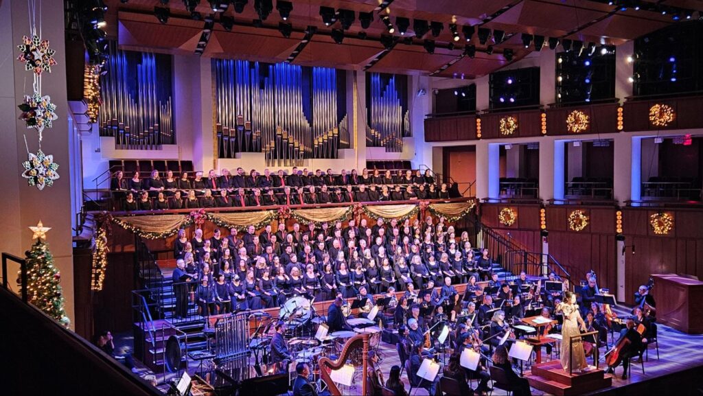 Artistic Director and Conductor Marie Bucoy-Calavan shares her story as a first-generation Filipino-American and highlights the Filipino parol (lantern, upper left) during the O Night Divine concert at the Kennedy Center on 15 December 2025. The performance also featured beloved Filipino Christmas songs, including “Ang Pasko ay Sumapit” and “Payapang Daigdig.”