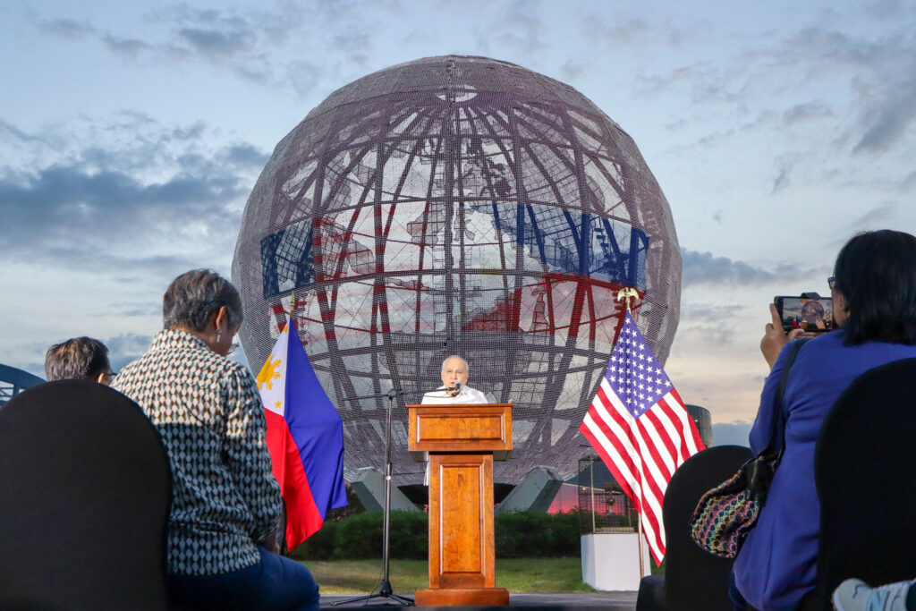 Philippine Ambassador to the United States Jose Manuel Romualdez delivers remarks beneath the illuminated SM Mall of Asia Globe displaying the 80th anniversary logo of Philippines&ndash;United States diplomatic relations. Photo Credit: DFA-OPD Johannes Adrian De Guia