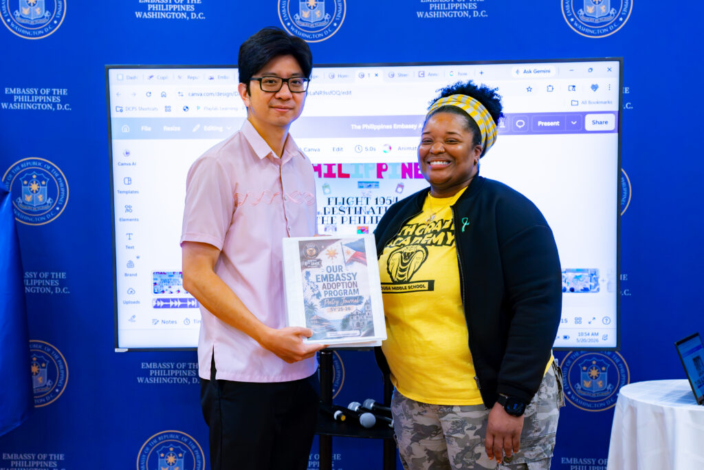 Ms. Brynn Rosser (right) presents to Consul Mark Lim a collection of original poems penned by her students as a result of their appreciation of the Philippines and its culture.